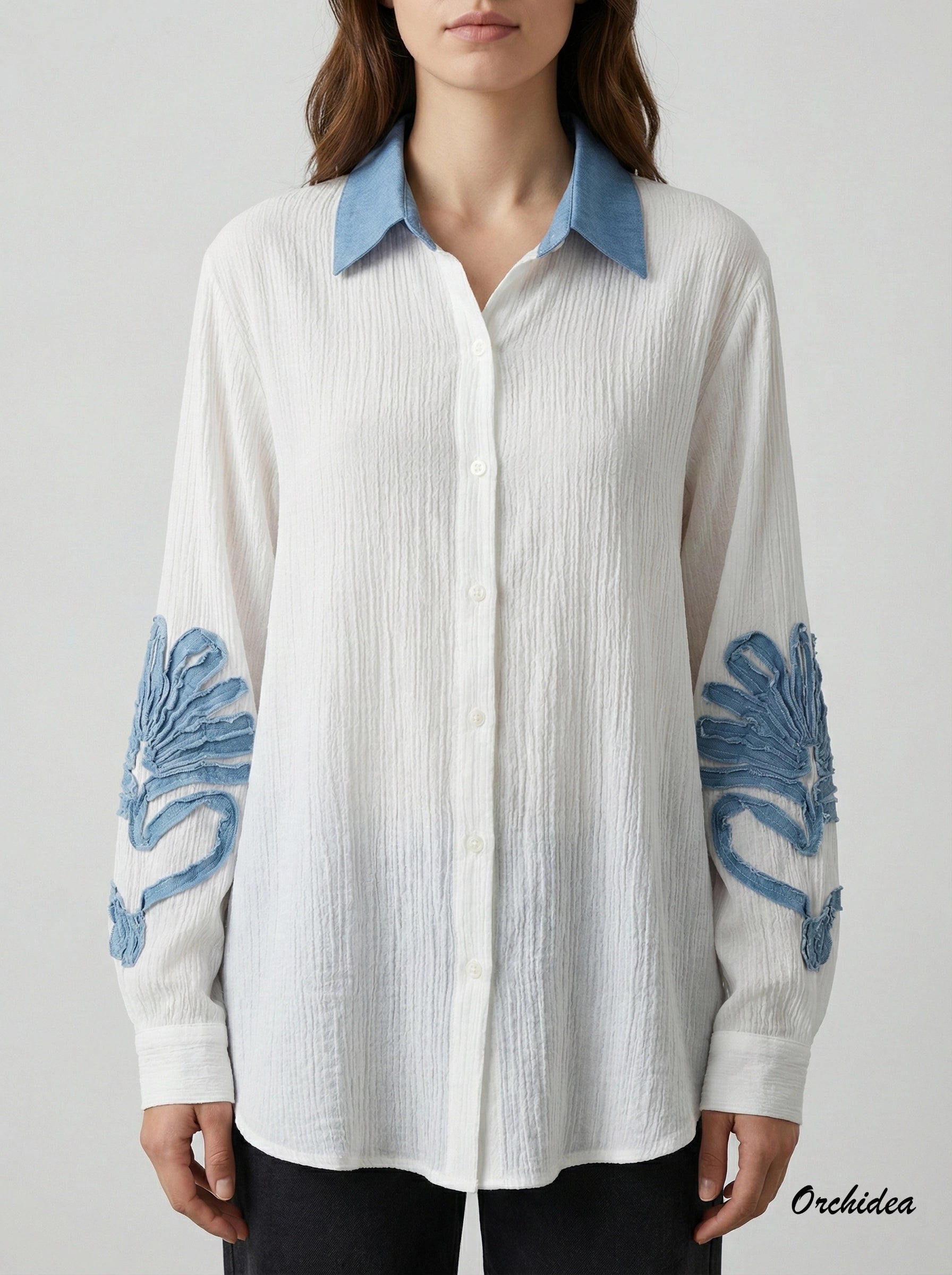 Bílá košile s modrými detaily a 3D aplikacemi na rukávech